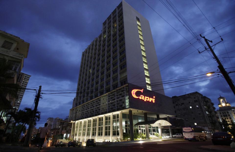 The hotel Capri is illuminated at dawn in Havana, Cuba, Friday, Feb. 14, 2014. Havana's hedonistic mob-and-movie-star days came to an end with Fidel Castro's 1959 revolution, and the hotel drifted into a long, slow decline. But now the Capri is back in business after being closed more than a decade ago. Its rebirth is part of Cuba's latest bid to trade on its colorful pre-Communist past and attract tourist dollars to fund its socialist present. (AP Photo/Franklin Reyes)