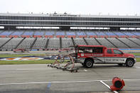 Trucks dry the track in an attempt to resume a NASCAR Cup Series auto race after morning rain prevented the rescheduled start at Texas Motor Speedway in Fort Worth, Texas, Monday, Oct. 26, 2020. (AP Photo/Richard W. Rodriguez)