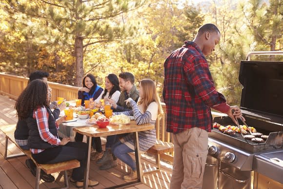 Friends having a barbecue on an outdoor deck.