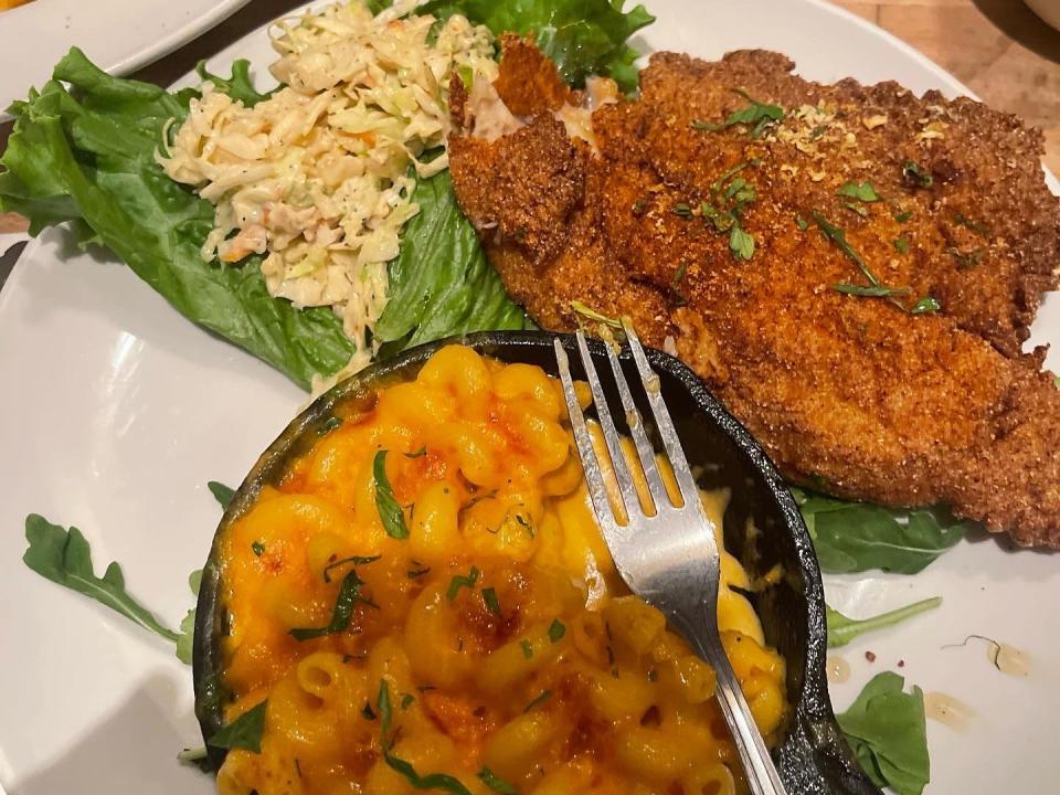 A plate of catfish, macaroni and cheese, and coleslaw.