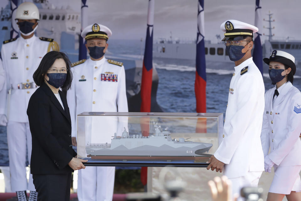 Taiwan's President Tsai Ing-wen, left, holds a model ship during the commissioning ceremony of the the domestically made Ta Jiang warship at the Suao naval base in Yilan county, Taiwan, Thursday, Sept. 9, 2021. Taiwan's president oversaw the commissioning of a new domestically made navy warship Thursday as part of the island's plan to boost indigenous defense capacity amid heightened tensions with China. (AP Photo/Chiang Ying-ying)