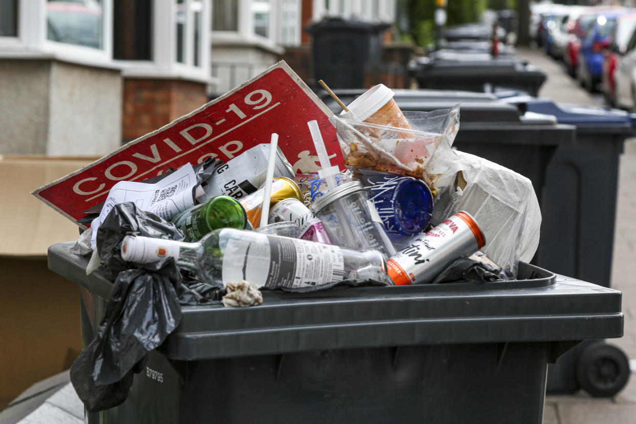 An overflowing bin with a Covid-19 sign on top in the build up of litter on Dawlish Road, Selly Oak, Birmingham. (SWNS)
