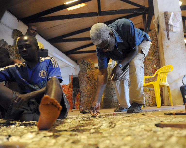 Ghanaian born, renowned sculptor Professor El Anatsui works with bottle caps at his Nsukka studio on August 8, 2013