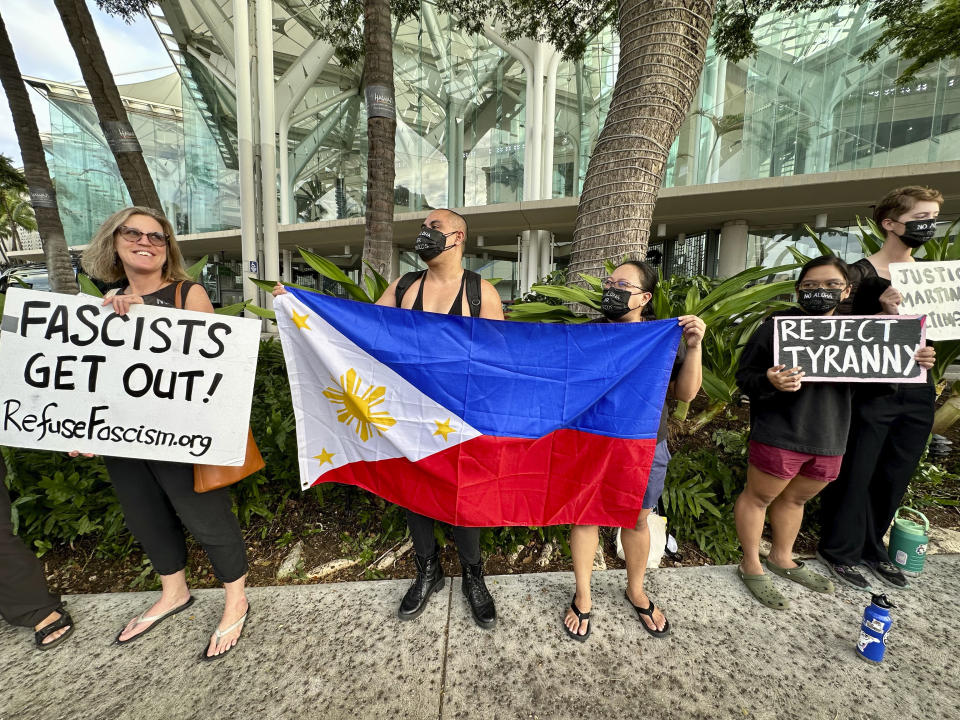 Protesters gather outside the Hawaii Convention Center in Honolulu on Saturday, Nov. 18, 2023, to protest a visit by Philippines President Ferdinand Marcos Jr. and recall the actions taken by his late dictator father, Ferdinand Marcos Sr. The younger Marcos and current president was in Honolulu for a whirlwind trip on the way home from the Asia-Pacific Economic Cooperation summit in San Francisco to emphasize U.S.-Philippines relations and meet with Filipino community members in Hawaii. (AP Photo/Jennifer Kelleher)