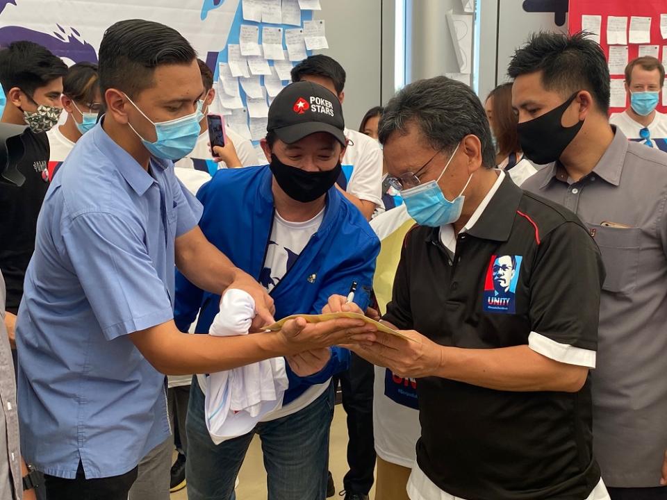 Shafie Apdal (second right) signs autographs for some of his supporters. — Picture courtesy of Sabah Chief Minister’s Department