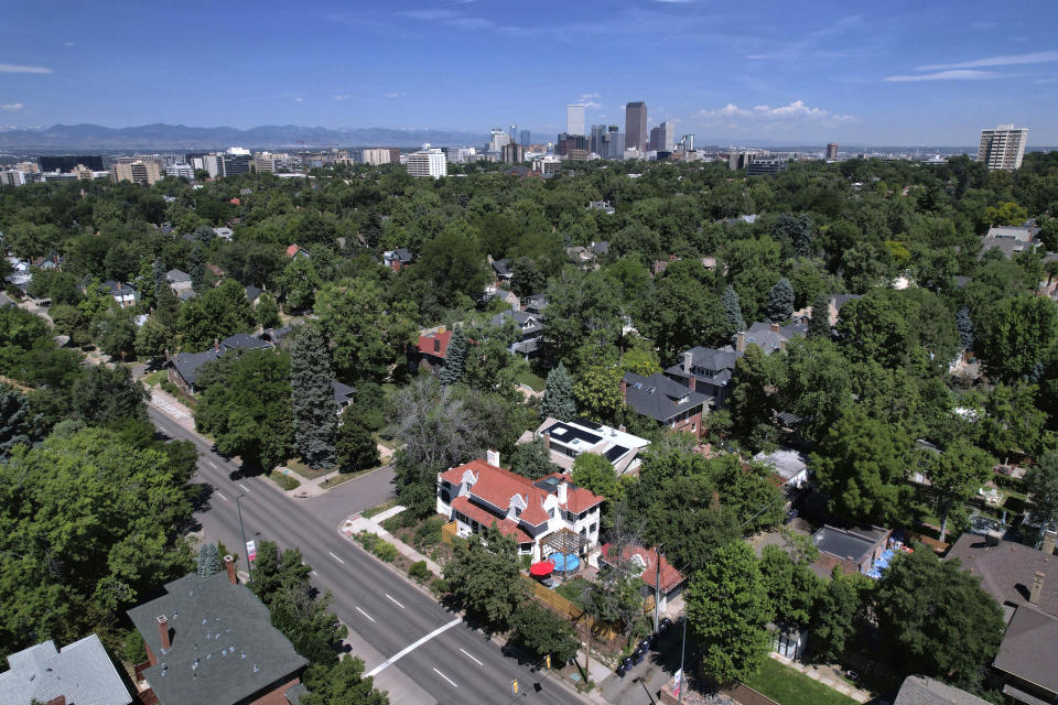 Mansions dot a tree-lined street in the Country Club neighborhood in Denver, July 24, 2023. Temperatures are hotter in America's low-income neighborhoods like the Denver suburb of Globeville, where many residents are low-income and people of color living in stretches of concrete that hold heat like a cast-iron skillet. Comparatively, in wealthy neighborhoods such as Country Club, mansions pocket a sea of vegetation which cools the area. (AP Photo/Brittany Peterson)