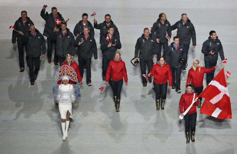 Lene Nielsen of Denmark holds the national flag and enters the arena with her teammates during the opening ceremony of the 2014 Winter Olympics in Sochi, Russia, Friday, Feb. 7, 2014. (AP Photo/Charlie Riedel)
