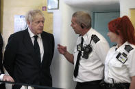 Britain's Prime Minister Boris Johnson talks with prison staff during a visit to Leeds prison, Northern England, Tuesday Aug. 13, 2019. In an announcement on Sunday Johnson promised more prisons and stronger police powers in an effort to fight violent crime. ( AP Photo/Jon Super)