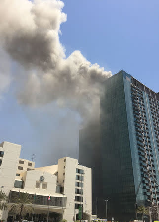 Smoke rises after a fire broke out in a building in Abu Dhabi, UAE, August 30, 2016. REUTERS/Stanley Carvalho