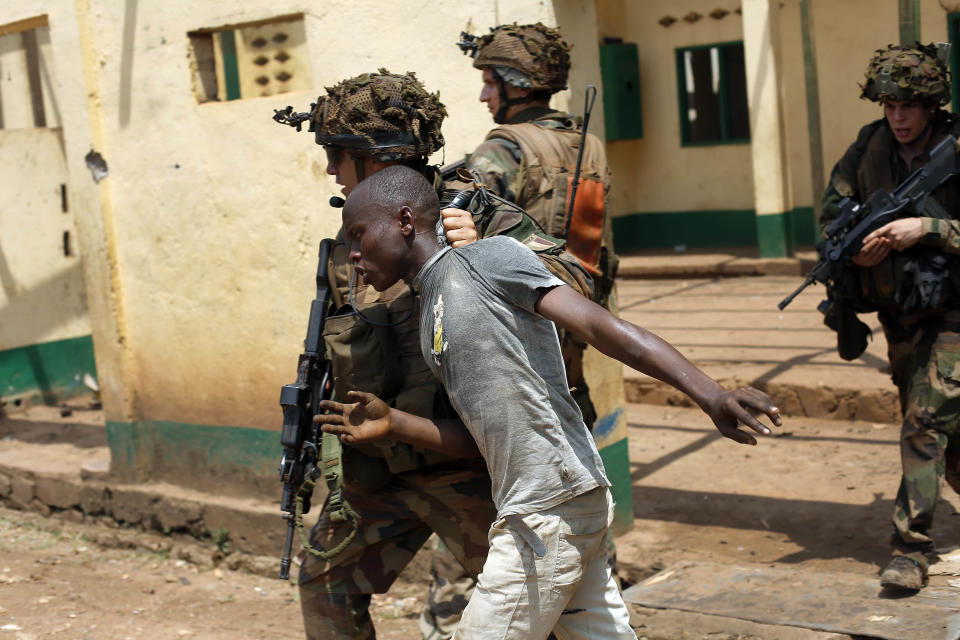 French forces grab a man looting a mosque before chasing him away in the Miskin district of Bangui, Central African Republic, Monday Feb. 3, 2014. Fighting between Muslim Seleka militias and Christian anti-Balaka factions continues as French and African Union forces struggle to contain the bloodshed. (AP Photo/Jerome Delay)