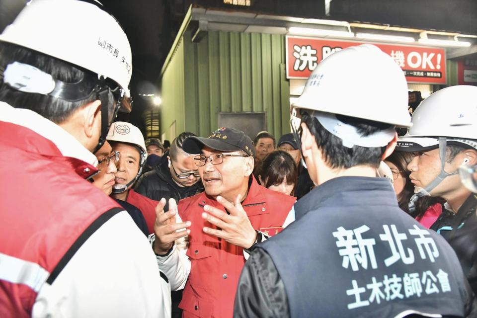 新北市三重區福隆路27日一處新建住宅工地開挖地下室，突然發生滲水情形，並造成附近有建物些微傾斜。（圖：侯友宜臉書）