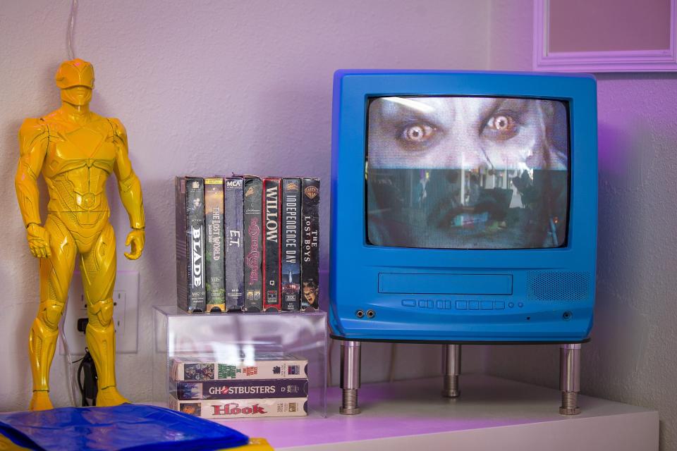 Used VHS tapes sit on display and play on a small blue TV behind the register of Eighty Seven in Phoenix on Nov. 20, 2021.