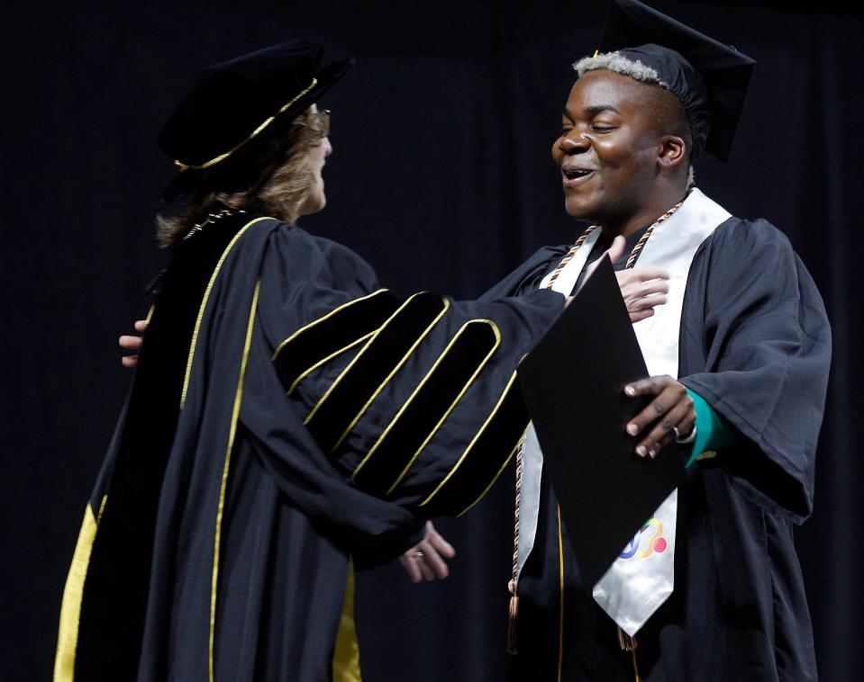 Framingham State University graduate Malik Isaiah Martin prepares to hug President Nancy Niemi after receiving his diploma during the graduation ceremonies at the DCU Center in Worcester, May 21, 2023.