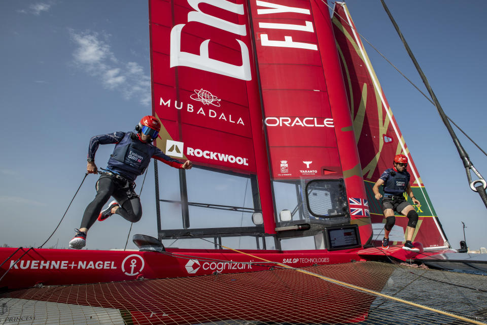 In this handout provided by SailGP, Ben Ainslie, left, driver of the Emirates Great Britain SailGP Team, and Matt Gotrel, grinder, run across the boat during a practice session ahead of the Italy Sail Grand Prix sailing event in Taranto, Italy, Friday, Sept. 22, 2023. (Ricardo Pinto/SailGP via AP)