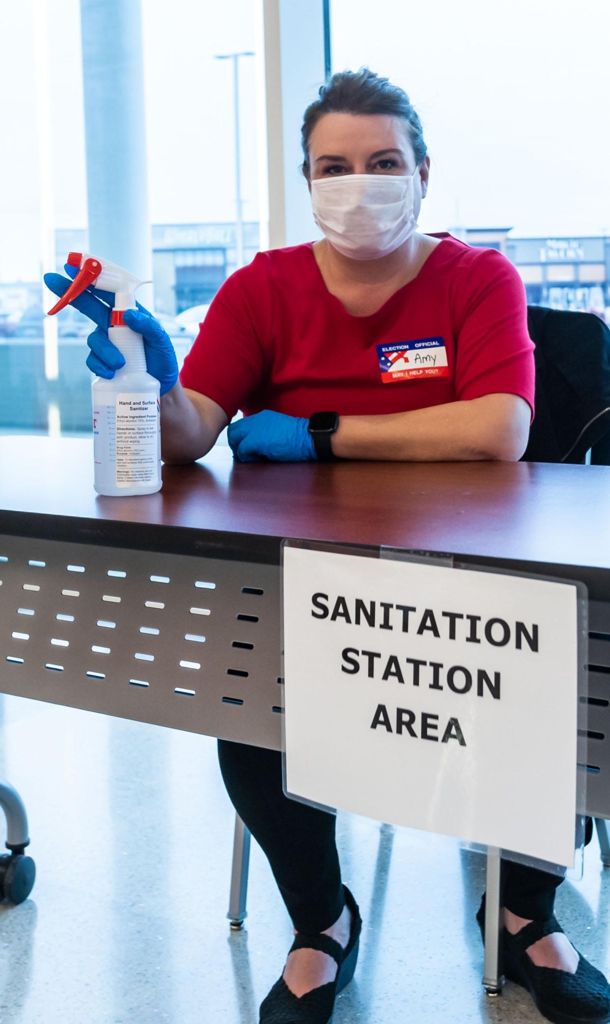 Poll worker Amy Schultz offers Brookfield voters sanitizer before they enter the Brookfield Conference Center at 325 S. Moorland Rd. on Tuesday, April 7, 2020.