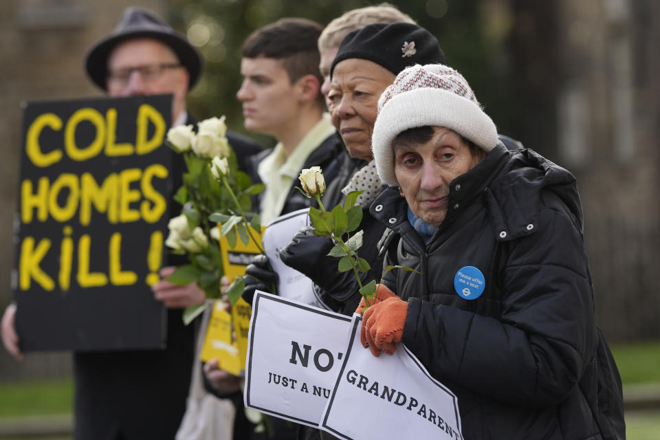 FILE - Protestors from Fuel Poverty Action group hold placards as they demonstrate over the number of excess deaths in Britain due to some pensioners unable to heat their homes in winter due to rising fuel costs in London, Thursday, Jan. 19, 2023. Britain's energy regulator said Thursday that the typical household energy bill will come down by around 400 pounds ($495) a year from July as global wholesale energy prices come down. (AP Photo/Alastair Grant, File)