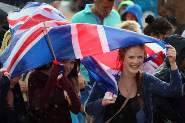 Members of the public shelter from the rain at the Olympic Park on Day 2 of the London 2012 Olympic Games on July 29, 2012 in London, England. (Photo by Jeff J Mitchell/Getty Images)