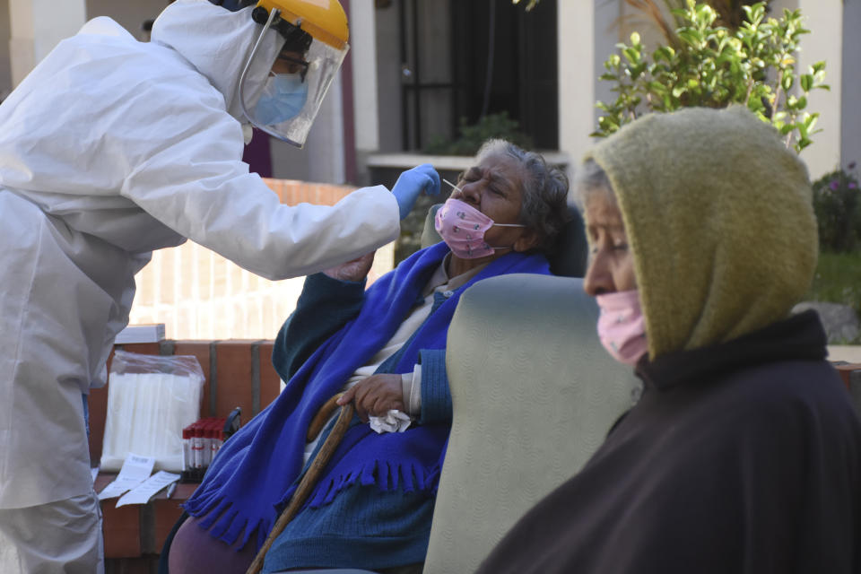 A healthcare worker takes samples to test elderly residents for the new coronavirus at the San Jose nursing home in Cochabamba, Bolivia, Friday, July 17, 2020. At least 60 residents at the senior care facility tested positive for the new coronavirus and 10 have died from related symptoms in the last two weeks, amid a rise in cases and fatalities in the Andean country. (AP Photo/Dico Solis)