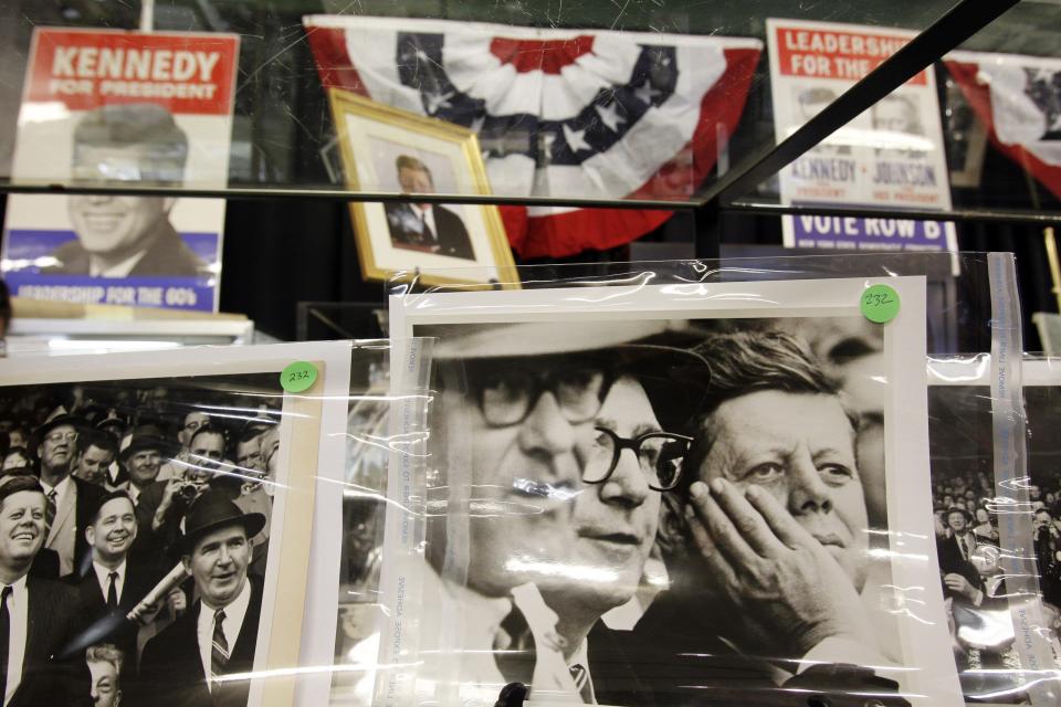 <p>Campaign posters are just visible behind pictures of the former President. A collection 2000 photographs, documents, gifts and other items were up for auction (Reuters)</p>