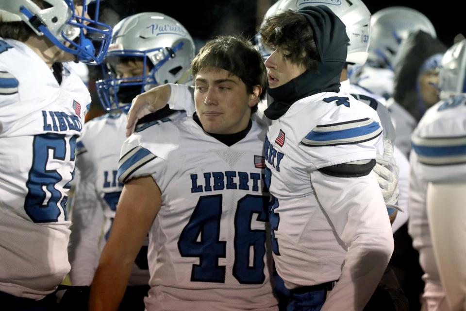 Olentangy Liberty's Jack Kendall (46) and Nathan Maag (4) console each other following a 35-7 loss to Springfield in an OHSAA Division I Regional Final game Nov. 18 at London High School.