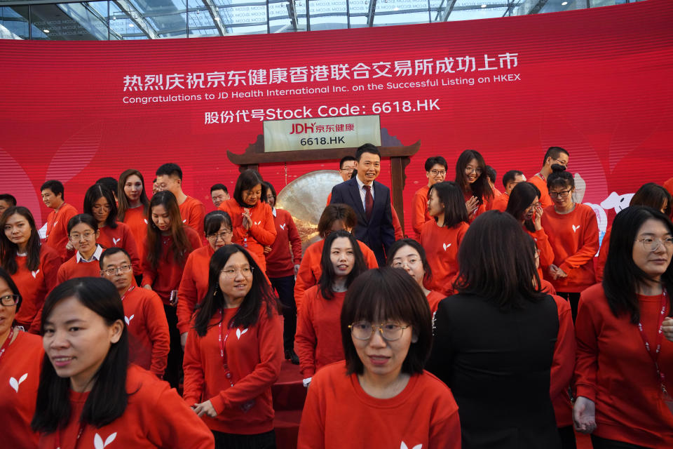 Xin Lijun, CEO of JD Health, stands amongst workers from the company during a ceremony to mark their stock listing on the Hong Kong stock exchange at the JD Headquarters in Beijing on Tuesday, Dec. 8, 2020. Shares in China's biggest online health care platform rose 40% in their Hong Kong stock market debut Tuesday, reflecting investor enthusiasm for the fledgling industry as the country emerges from the coronavirus pandemic. (AP Photo/Ng Han Guan)