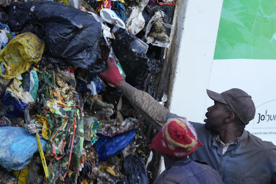 Waste pickers rummage through garbage, at a dumping site in Johannesburg, South Africa, Friday, May 20, 2022. Environmental activists are gathering in South Africa this week to press governments and businesses to reduce the production of plastic because it is harming the continent's environment. (AP Photo/Themba Hadebe)