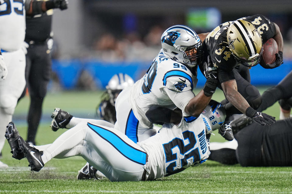 New Orleans Saints running back Tony Jones Jr. is tackled by Carolina Panthers safety Xavier Woods (25) and defensive tackle Shy Tuttle (99) during the second half of an NFL football game Monday, Sept. 18, 2023, in Charlotte, N.C. (AP Photo/Rusty Jones)