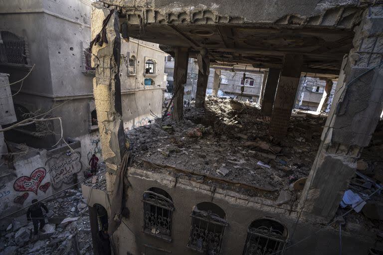 Palestinos revisan una casa destruida en el bombardeo israelí sobre Rafah, Franja de Gaza, lunes 11 de diciembre de 2023.
