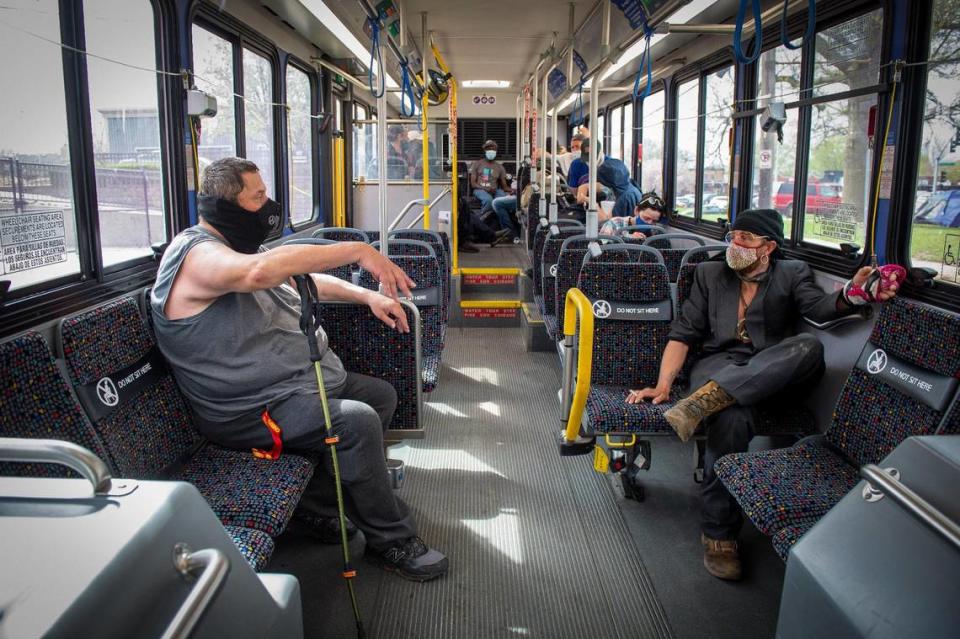 Jeff Rogers, left, and others in need of shelter, sat on a bus outside Camp 6ixx in Westport to be taken to a local hotel on Friday, April 9, for housing. Mayor Quinton Lucas and the City Council fast-tracked a plan to provide hotel rooms for some of those without shelter for up to 90 days. Rogers said the hotel room would provide him a stable environment for him to line up stable housing and a hip replacement.