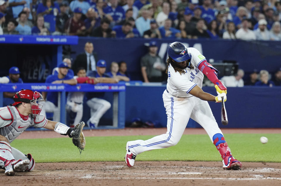 Toronto Blue Jays' Vladimir Guerrero Jr. (27) grounds into a double play as Philadelphia Phillies catcher J.T. Realmuto (10) looks on during the sixth inning of a baseball game in Toronto, Tuesday, Aug. 15, 2023. (Nathan Denette/The Canadian Press via AP)