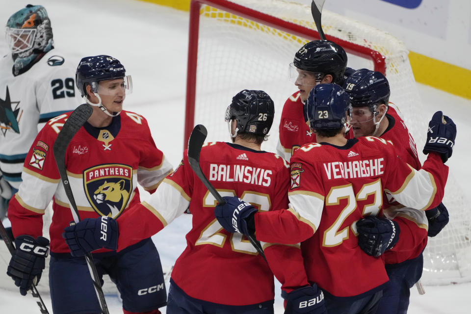 Florida Panthers center Carter Verhaeghe (23) is congratulated by his teammates after scoring a goal during the second period of an NHL hockey game against the San Jose Sharks, Tuesday, Oct. 24, 2023, in Sunrise, Fla. (AP Photo/Marta Lavandier)