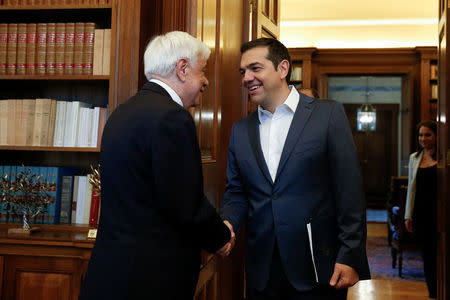 Greek Prime Minister Alexis Tsipras shakes hands with Greek President Prokopis Pavlopoulos before briefing him on developments on the name dispute with Macedonia, in Athens, Greece May 19, 2018. REUTERS/Costas Baltas