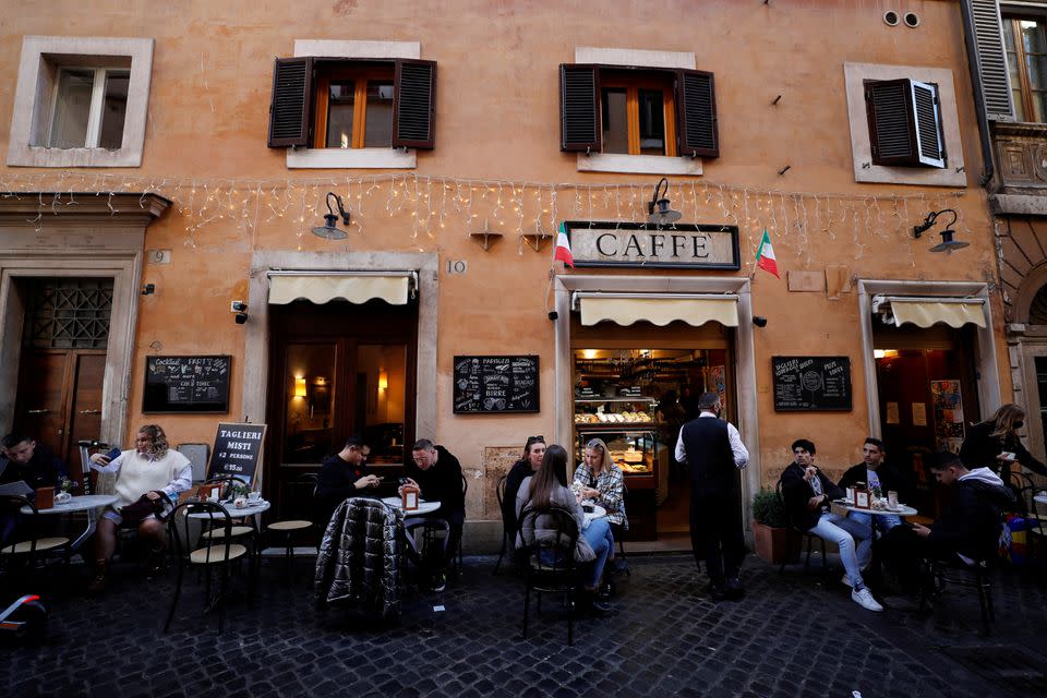 People sit at a bar, as the government discusses more stringent rules for the coronavirus disease (COVID-19) health pass known as a Green Pass, in Rome (Reuters)