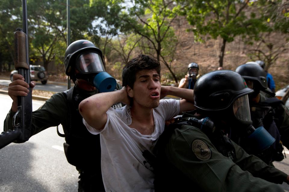 A n anti-government demonstrator is detained by Bolivarian national Guards during a protest in Caracas, Venezuela, Saturday, April 26, 2014. Student organizers at the last minute decided against marching downtown to avoid a confrontation with security forces in the government-controlled district. Instead they concentrated in the wealthier, eastern neighborhoods that have been the hotbed of unrest since February. (AP Photo/Fernando Llano)