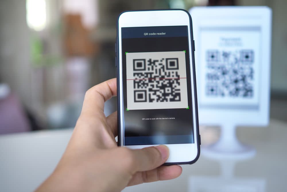 A person scan a QR code with a phone.