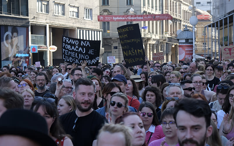 People march with signs in solidarity with a woman who was denied an abortion in Croatia