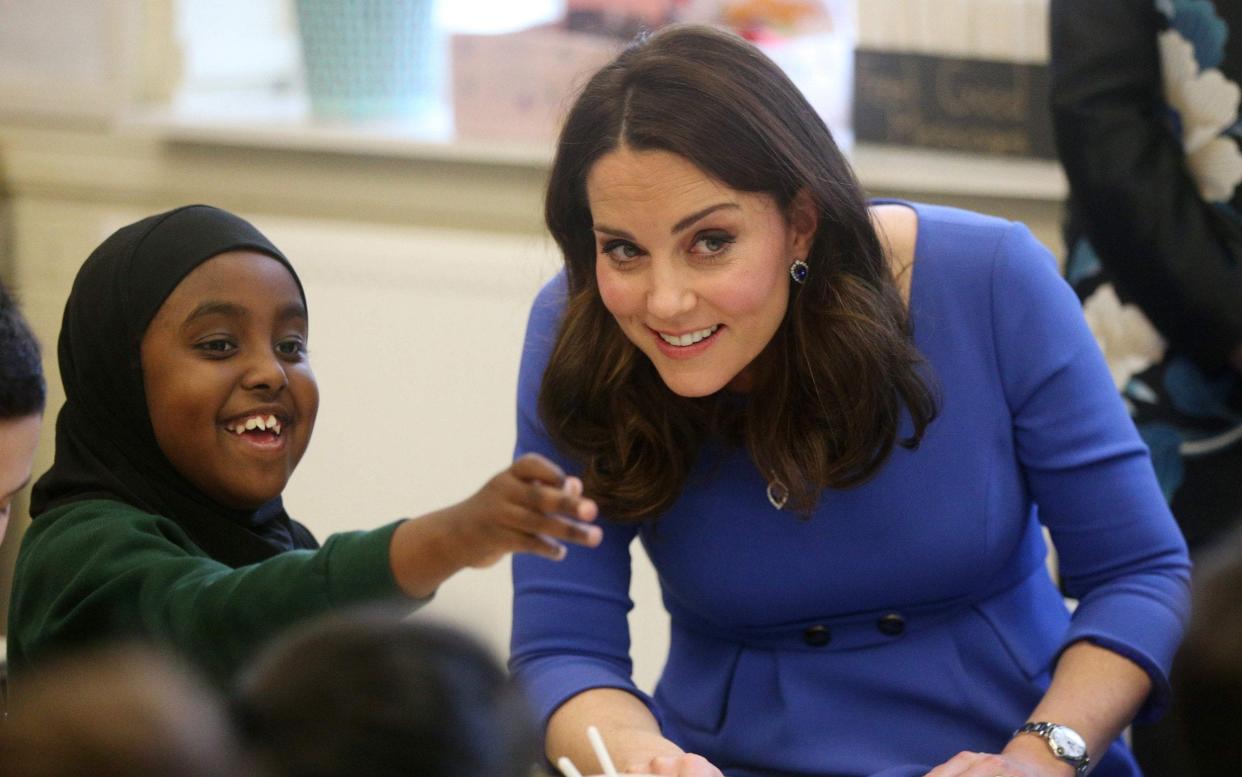 The Duchess of Cambridge meets a pupil at Roe Green Junior School - AFP