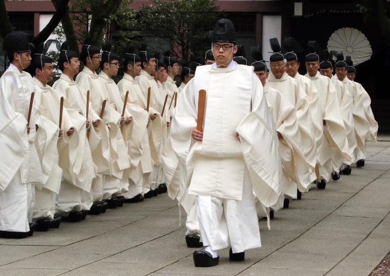 Shinto priests walk to the main shrine as they administer a Shinto rite 'Kiyoharai' on the first day of the three-day spring festival, at the Yasukuni shrine in Tokyo, on April 21, 2015