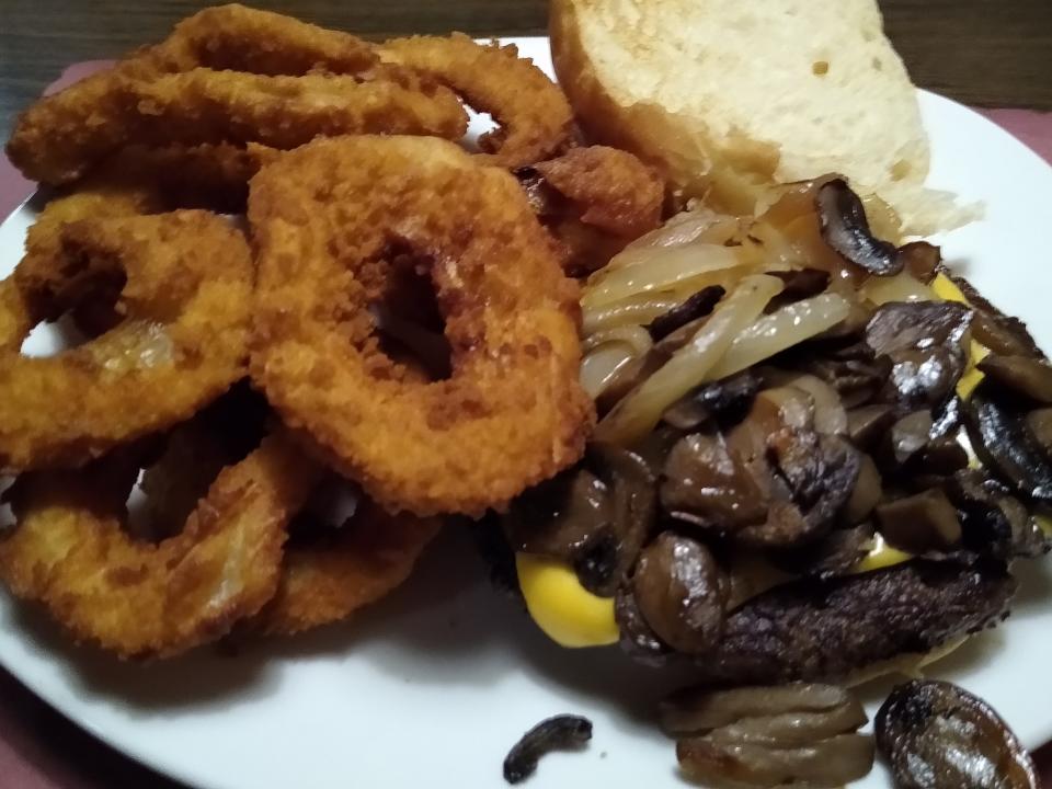 The Famous Ido Burger is topped with grilled mushrooms, onions and American cheese. Onion rings can be added as a side.