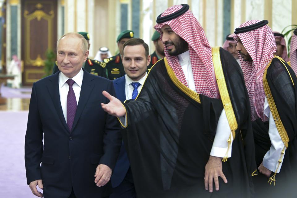 Saudi Crown Prince Mohammed bin Salman, right, welcomes Russian President Vladimir Putin for the talks at the Al Yamamah Palace in Riyadh, Saudi Arabia, on Wednesday, Dec. 6, 2023. At top a picture showing Saudi King Salman. (Alexei Nikolsky, Sputnik, Kremlin Pool Photo via AP)