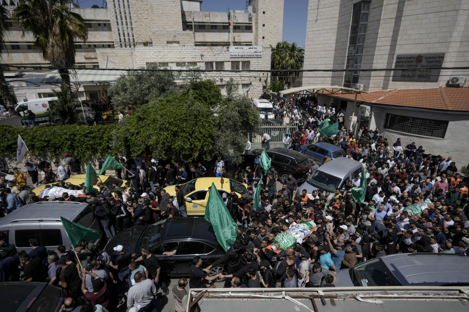 Palestinians carry the bodies of Hassan Qatnani, Moaz al-Masri and Ibrahim Jabr, draped in the Hamas militant group flags, during their funeral in the West Bank city of Nablus, Thursday, May 4, 2023. The Israeli military says it has killed three Palestinians wanted for an attack last month on a car near a Jewish West Bank settlement that killed a British-Israeli mother and two of her daughters. Hamas said the men were its members and claimed responsibility for the attack. (AP Photo/Majdi Mohammed)