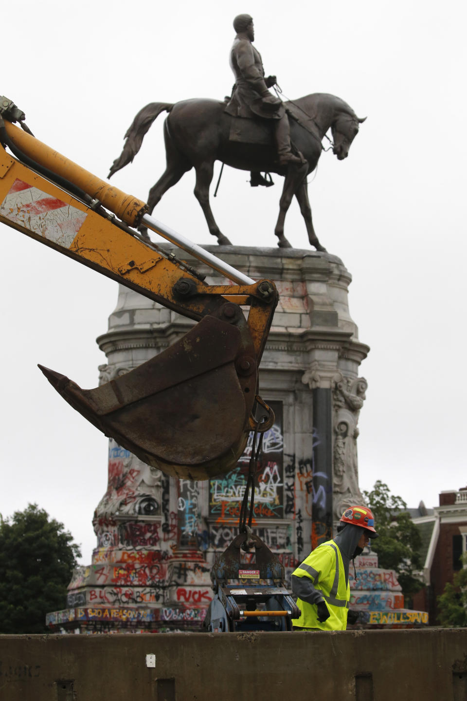 Workers for The Virginia Department of General Services install concrete barriers around the statue of Confederate General Robert E. Lee on Monument Avenue Wednesday June 17, 2020, in Richmond, Va. The barriers are intended to protect the safety of demonstrators as well as the structure itself. (AP Photo/Steve Helber)