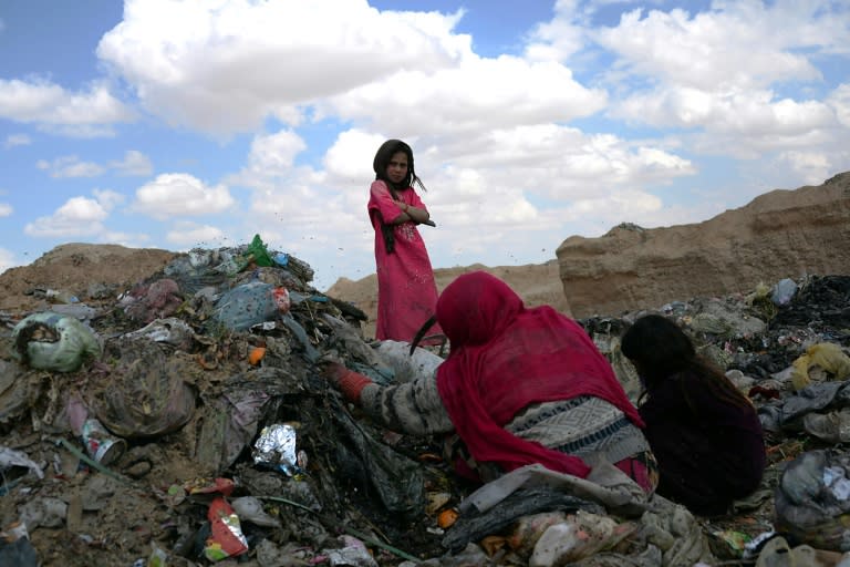 Girls search through garbage for recyclable items in Mazar-i Sharif on April 13, 2014