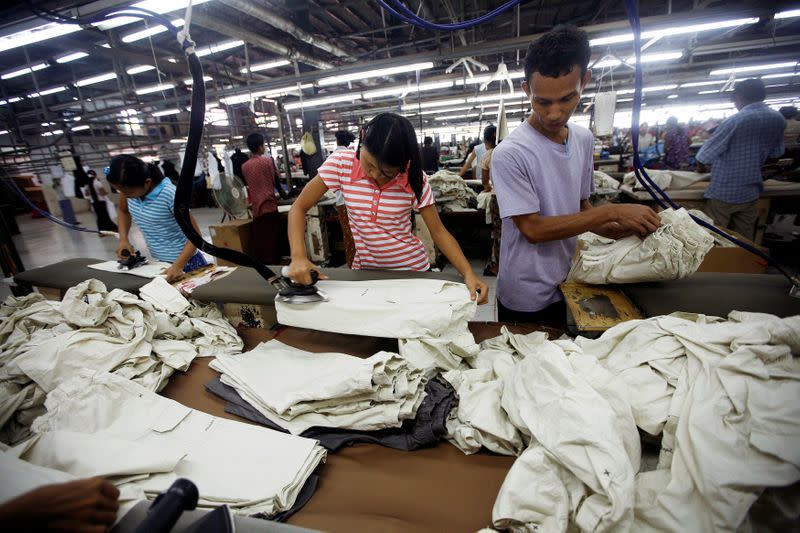 FILE PHOTO: Workers iron and arrange clothing at a garment factory at Hlaing Tar Yar industry zone in Yangon