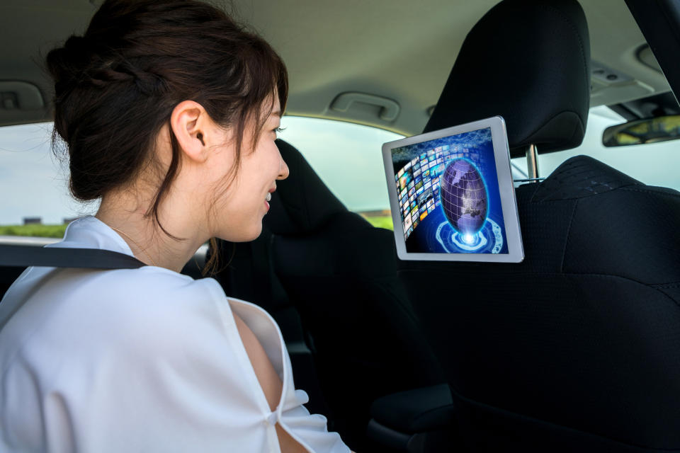 young woman watching screen in rear of vehicle
