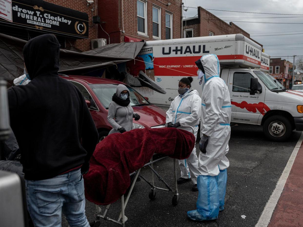 People in Hazmat suits transport a deceased body on a stretcher outside a funeral home in Brooklyn on April 30, 2020 in New York City. - Dozens of bodies have been discovered in unrefrigerated overflow trucks outside the Andrew T. Cleckley Funeral Home, following a complaint of a foul odor. (Photo by Johannes EISELE / AFP) (Photo by JOHANNES EISELE/AFP via Getty Images): Getty Images