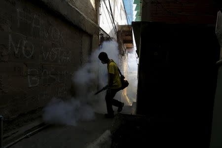 A municipal worker fumigates the Petare slum to help control the spread of the mosquito-borne Zika virus in Caracas, February 3, 2016. REUTERS/Marco Bello