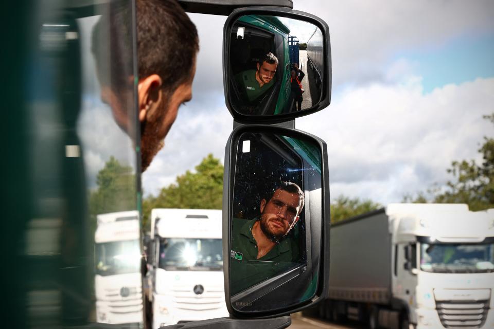 British driver Steven Abbott, 35, sits in his cab while taking a break from driving at Ashford International truck stop, in south-east England on October 5, 2021. - Sat at a truck stop between London and the Channel Tunnel, Dean Arney, who has worked as an HGV diver for 40 years sees little to recommend the work. 