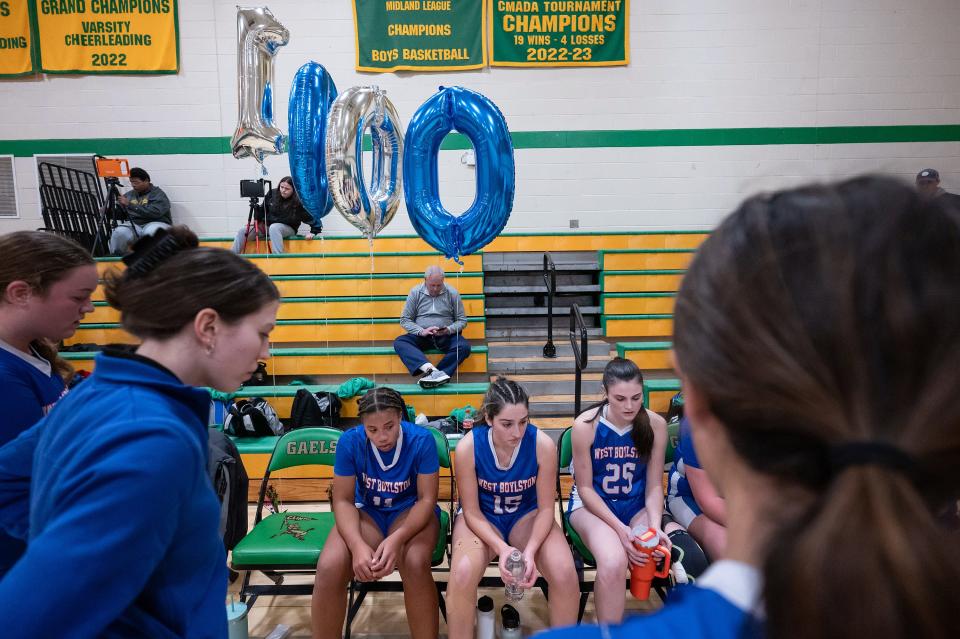 Balloons saying "1000" decorate the West Boylston bench after Maddie Pitro, center, scored her 1,000th point during the Clinton Holiday Tournament.