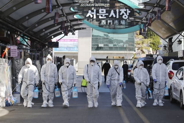 Workers spray disinfectant at a local market in Daegu, South Korea